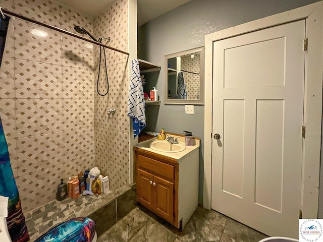 bathroom featuring a tile shower and vanity
