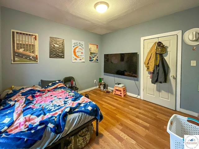 bedroom featuring wood finished floors and baseboards