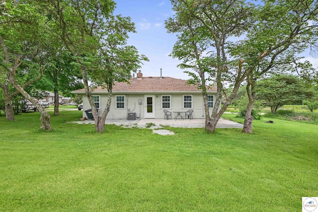 810 Harris St, Clinton, MO 64735 - back of property featuring a patio, a yard, central air condition unit, and a chimney
