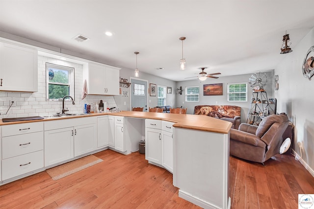 810 Harris St, Clinton, MO 64735 - kitchen featuring open floor plan, a peninsula, light wood-style flooring, a sink, and ceiling fan