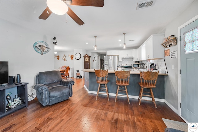 810 Harris St, Clinton, MO 64735 - kitchen with appliances with stainless steel finishes, a peninsula, tasteful backsplash, light countertops, and a ceiling fan