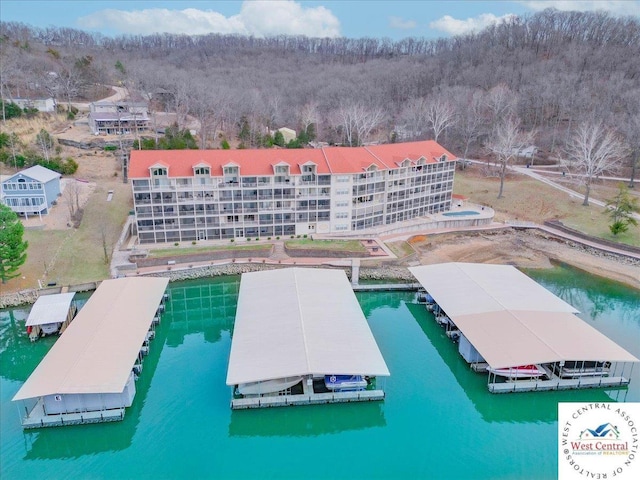 drone / aerial view with a wooded view and a water view