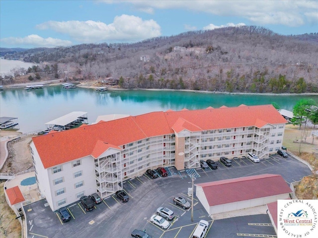 bird's eye view with a water view and a wooded view