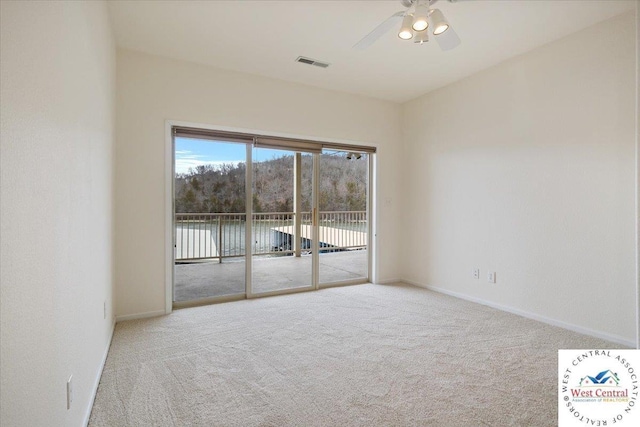 carpeted empty room featuring visible vents, ceiling fan, and baseboards