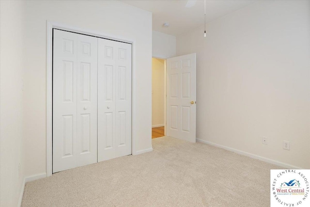 unfurnished bedroom with baseboards, carpet floors, and a closet