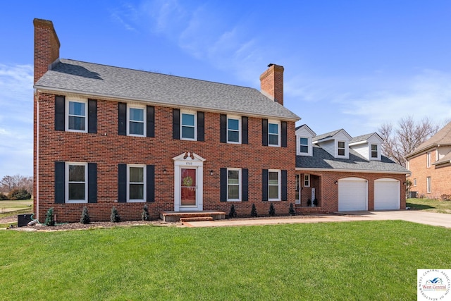 colonial-style house featuring a front yard, brick siding, and a chimney