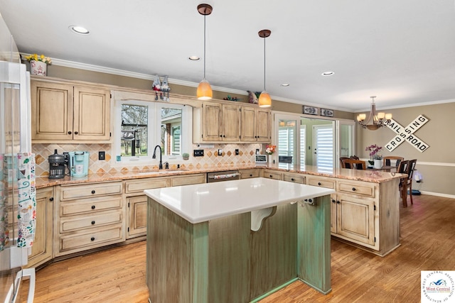 kitchen featuring decorative backsplash, a chandelier, a sink, a center island, and a peninsula