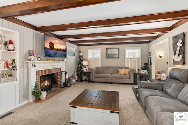 carpeted living area featuring beam ceiling, visible vents, and a fireplace