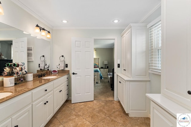 ensuite bathroom with double vanity, ornamental molding, tile patterned flooring, and a sink