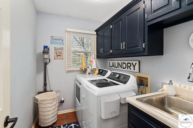 washroom with tile patterned flooring, washer and dryer, cabinet space, a sink, and baseboards