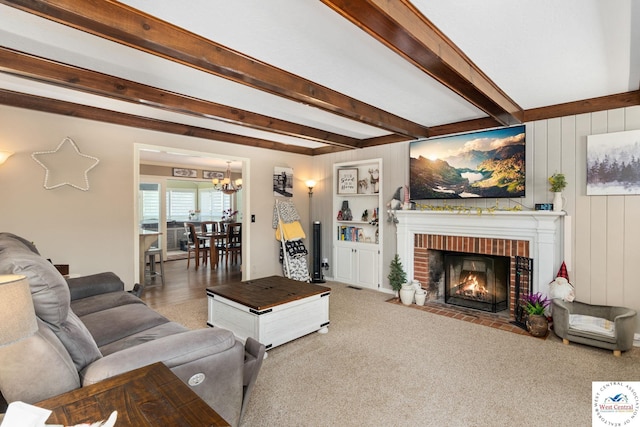 living area with an inviting chandelier, beam ceiling, and a brick fireplace