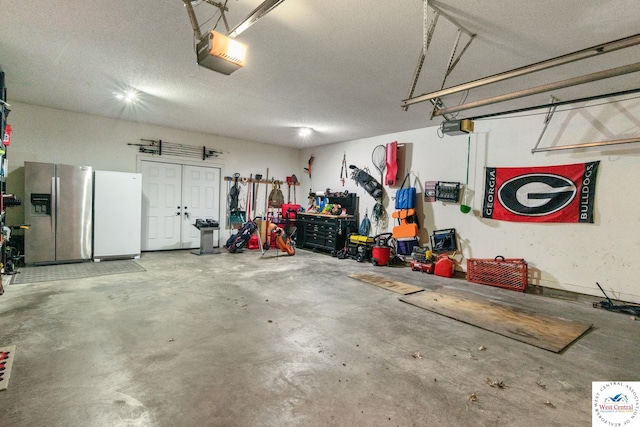 garage featuring stainless steel refrigerator with ice dispenser, freestanding refrigerator, and a garage door opener