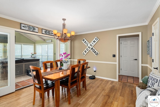 dining space with baseboards, ornamental molding, a notable chandelier, and light wood finished floors