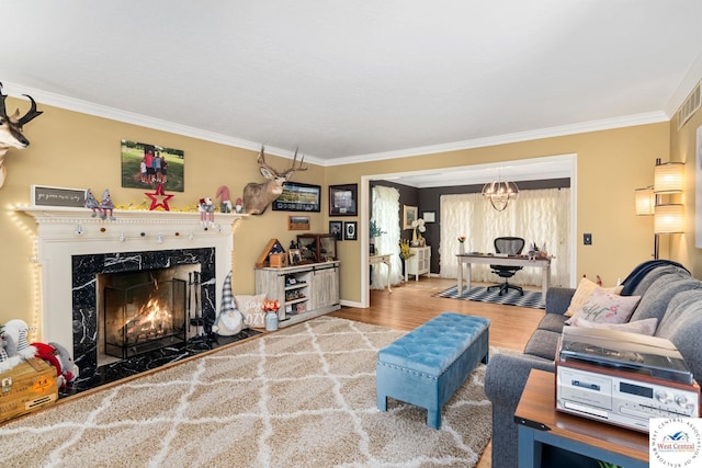 living area with crown molding, baseboards, wood finished floors, and a fireplace