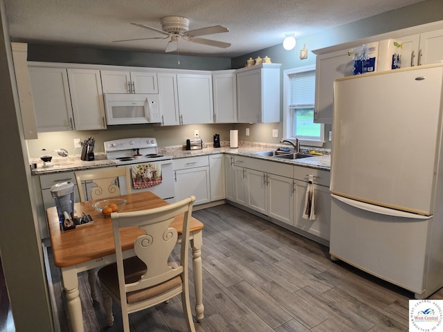 810 E Cedar St, Clinton, MO 64735 - kitchen featuring white appliances, a sink, a ceiling fan, white cabinetry, and light wood-style floors