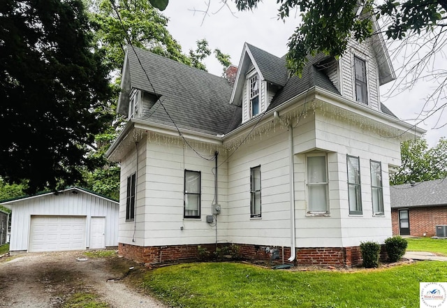 902 N 2nd St, Clinton, MO 64735 - view of property exterior with an outdoor structure, a garage, a shingled roof, cooling unit, and driveway