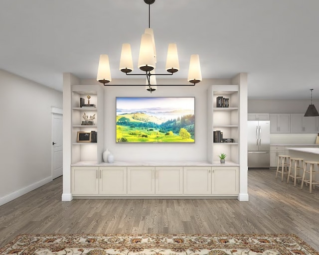unfurnished living room featuring baseboards, an inviting chandelier, and light wood-style floors