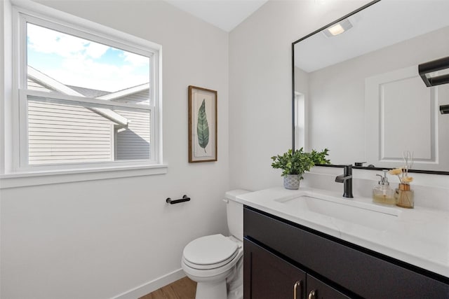 bathroom with vanity, toilet, and wood-type flooring