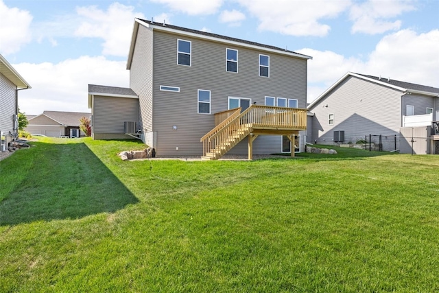 back of property with a yard and a wooden deck