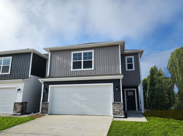 view of front facade featuring stone siding, driveway, and board and batten siding