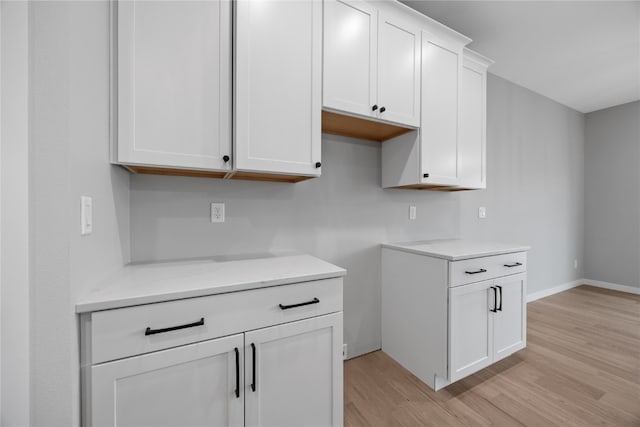 kitchen with light hardwood / wood-style flooring and white cabinetry