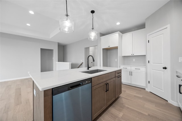 kitchen featuring sink, white cabinetry, light hardwood / wood-style floors, stainless steel dishwasher, and a kitchen island with sink