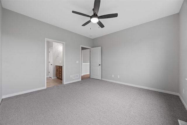 unfurnished bedroom featuring connected bathroom, ceiling fan, and light colored carpet