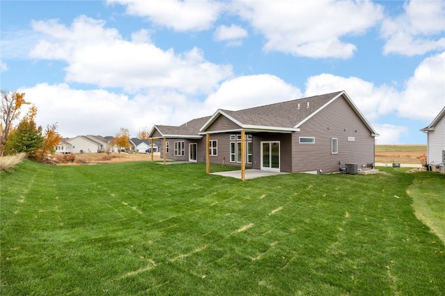 rear view of house featuring central air condition unit, a patio area, and a lawn