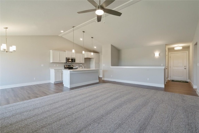 unfurnished living room featuring dark hardwood / wood-style flooring, ceiling fan with notable chandelier, vaulted ceiling, and sink