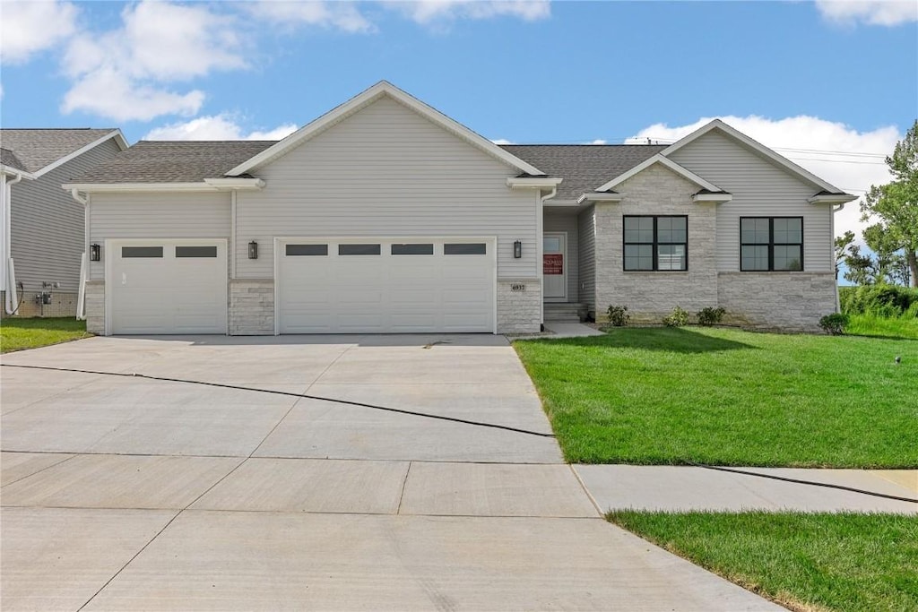 view of front facade with concrete driveway, a front lawn, and an attached garage