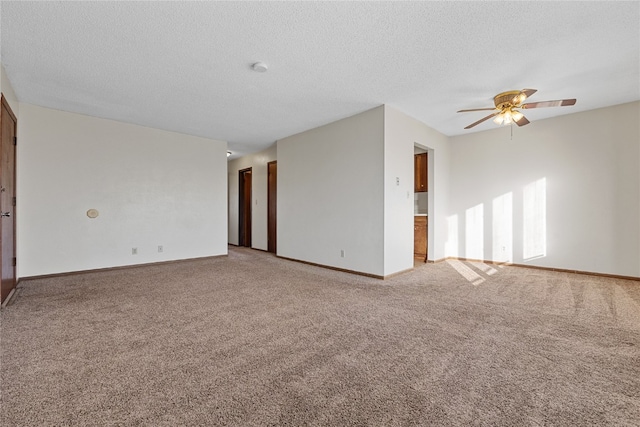 spare room featuring ceiling fan, a textured ceiling, and light carpet