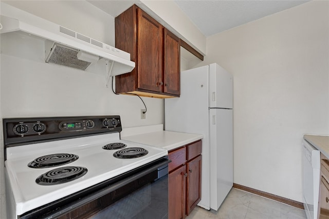 kitchen featuring white dishwasher, range, light tile floors, and wall chimney range hood