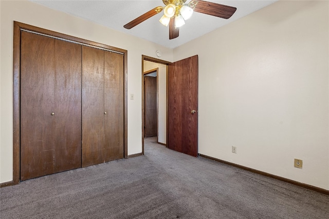 unfurnished bedroom with ceiling fan, dark colored carpet, and a closet