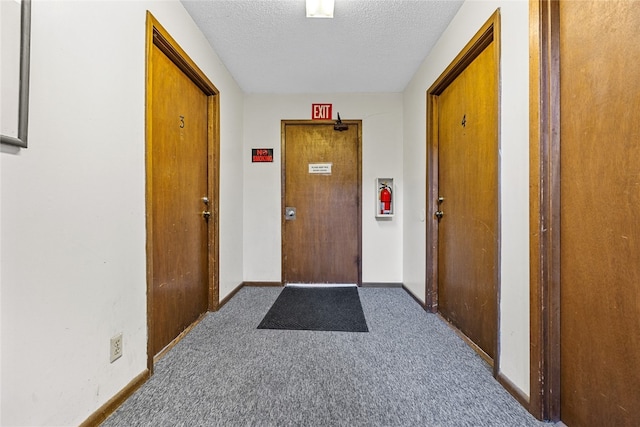 carpeted entrance foyer with a textured ceiling