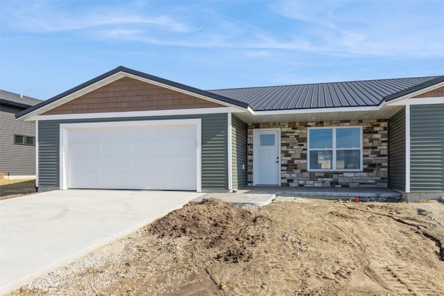 single story home featuring concrete driveway, an attached garage, stone siding, and metal roof