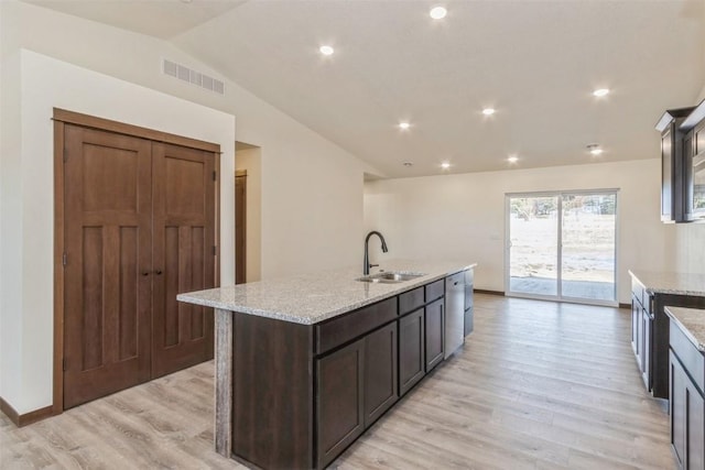 kitchen featuring visible vents, light wood-type flooring, a sink, stainless steel dishwasher, and vaulted ceiling