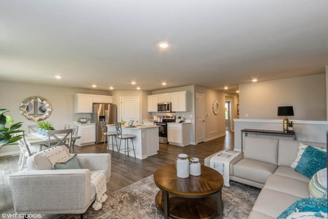 living area featuring dark wood finished floors, recessed lighting, and baseboards