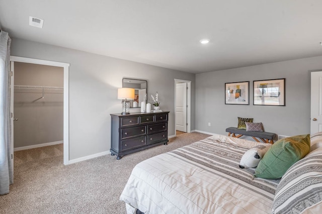 bedroom with a spacious closet, light carpet, and a closet