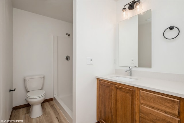 bathroom with toilet, vanity with extensive cabinet space, walk in shower, and wood-type flooring