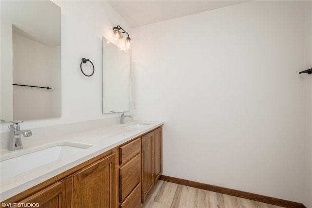 bathroom featuring double sink, large vanity, and hardwood / wood-style flooring