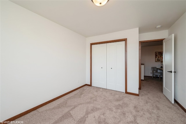 unfurnished bedroom featuring a closet and light colored carpet