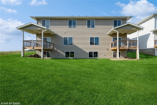 rear view of house featuring a lawn and a deck