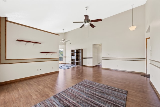 unfurnished living room featuring a high ceiling, wood-type flooring, and ceiling fan