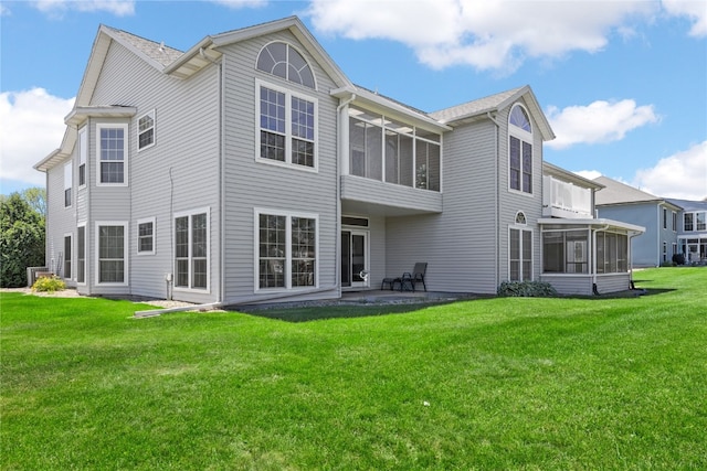 back of house with a patio, a sunroom, and a lawn