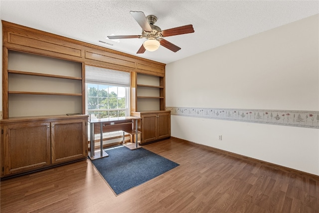 office space featuring ceiling fan, dark hardwood / wood-style flooring, and a textured ceiling