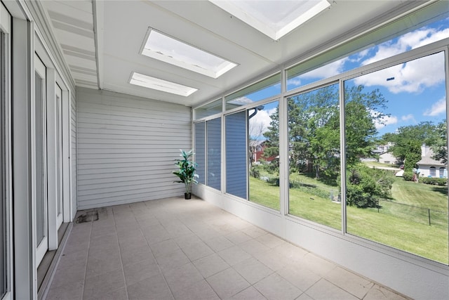 unfurnished sunroom with a wealth of natural light and a skylight