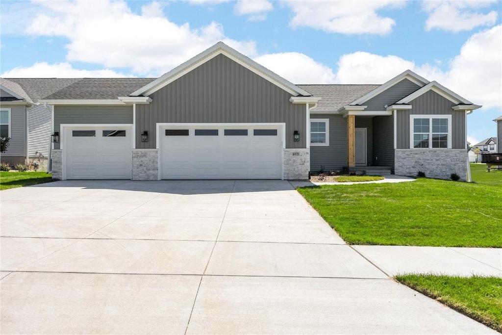 view of front of house with a garage, a front lawn, board and batten siding, and concrete driveway