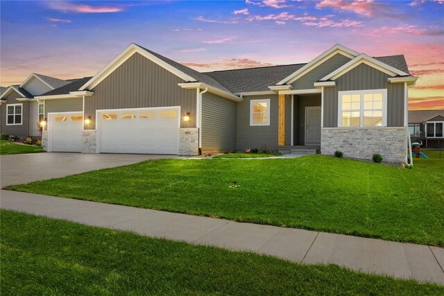 view of front of home with a garage and a yard