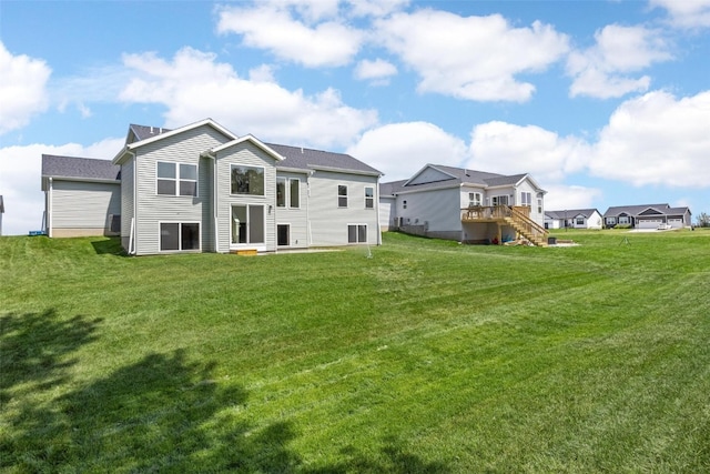 rear view of property featuring a yard and a deck