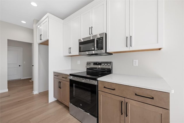 kitchen featuring stainless steel appliances, recessed lighting, light wood-style flooring, white cabinetry, and baseboards